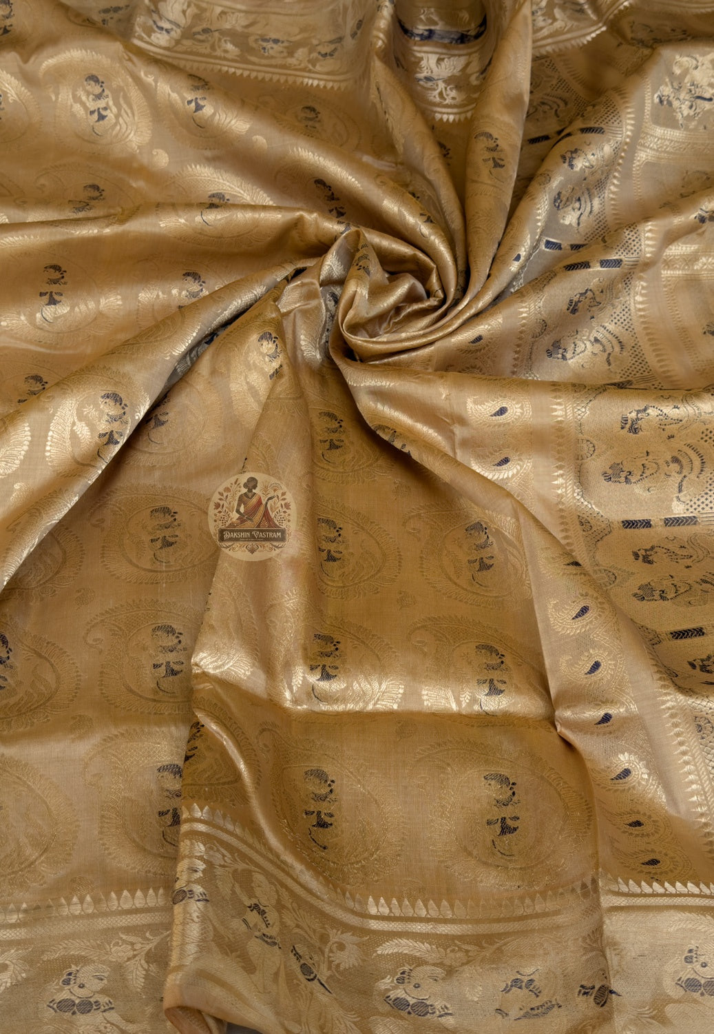 Close-up of premium Swarnachari handloom silk saree body showing precisely drawn and evenly spaced golden zari butis (small woven motifs) on warm pure silk ground, sustained weaver attention throughout