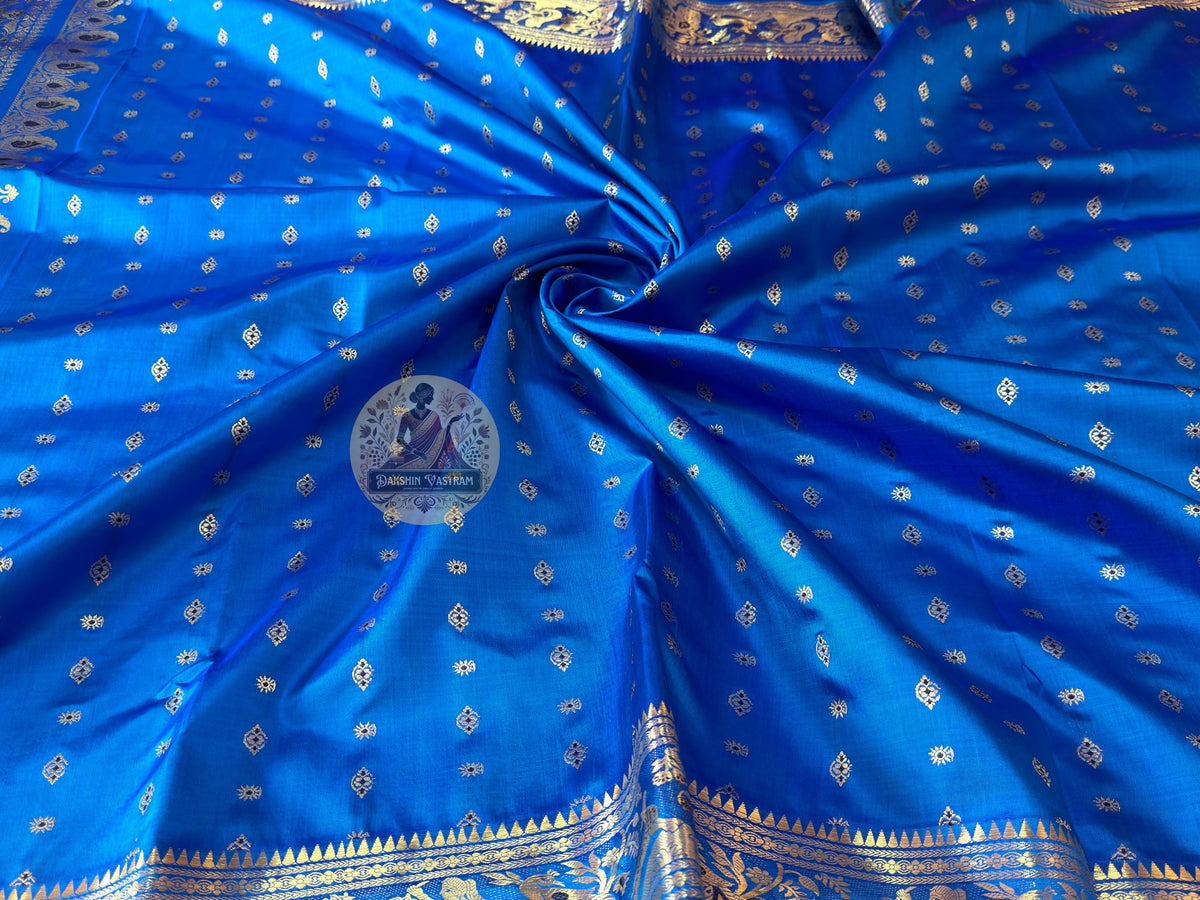 Close-up of pallu of blue Swarnachari pure silk saree showing golden zari Bishnupur temple art and mythology narrative composition on distinctive indigo silk ground West Bengal