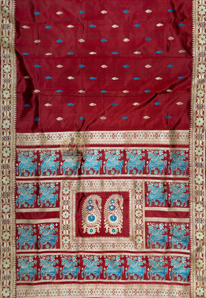 Close up of maroon Baluchari silk saree pallu with blue horses and riders surrounding paired paisley motifs