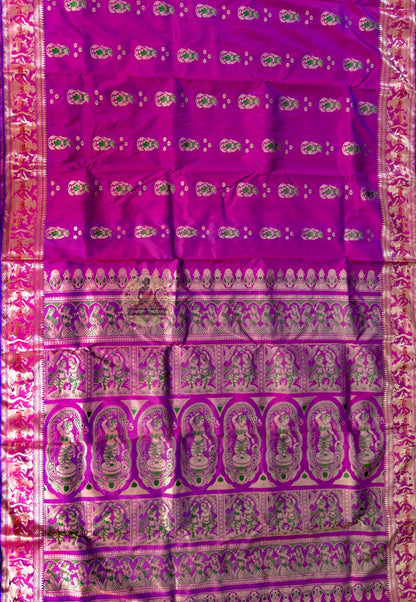 Side view of purple Swarnachari pure silk saree displaying natural fluid drape and golden zari brightening against deep purple silk in the amber light of Durga Puja Sandhi Puja evening