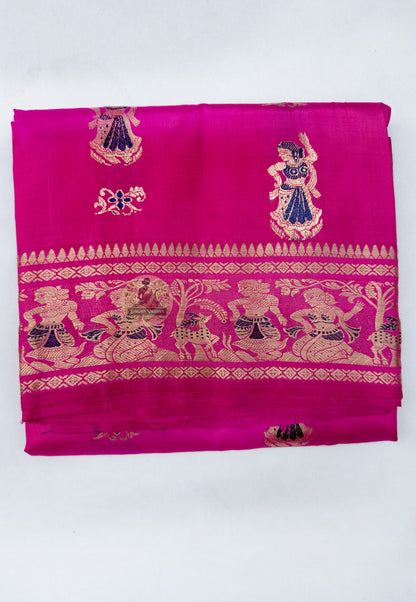 Close up of warm gold-toned figurative motifs and delicate accents on the rani pink saree body