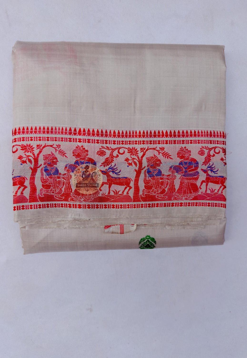 Close up of red, green and dark-toned motifs on the cream Baluchari silk saree body