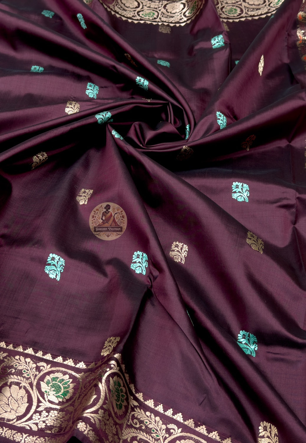 Rear view of Swarnachari silk saree displaying golden zari pallu with hand-woven Bengal temple and Ramayana dialogue compositions, weaver's response to tradition held in gold