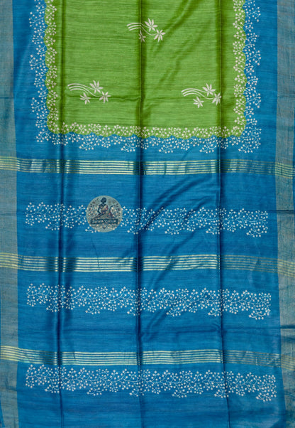 Close up of pale floral sprays with curved stems on the green saree body
