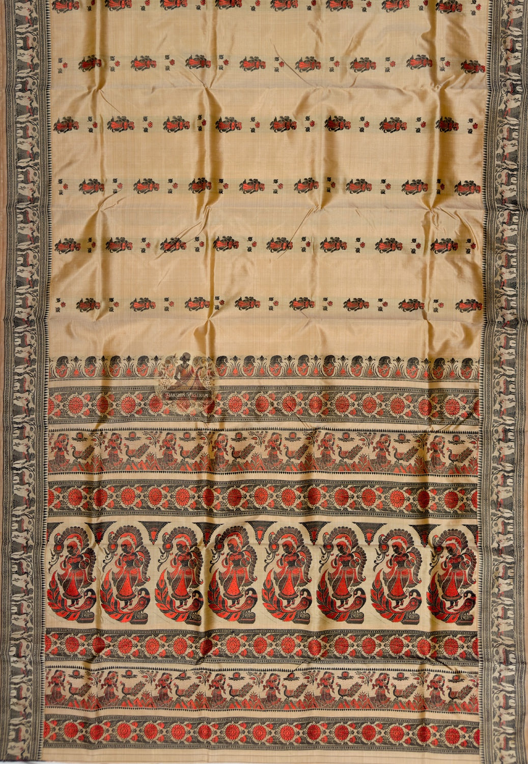 Full saree view of beige Baluchari silk saree with repeating red motifs and a decorative pallu