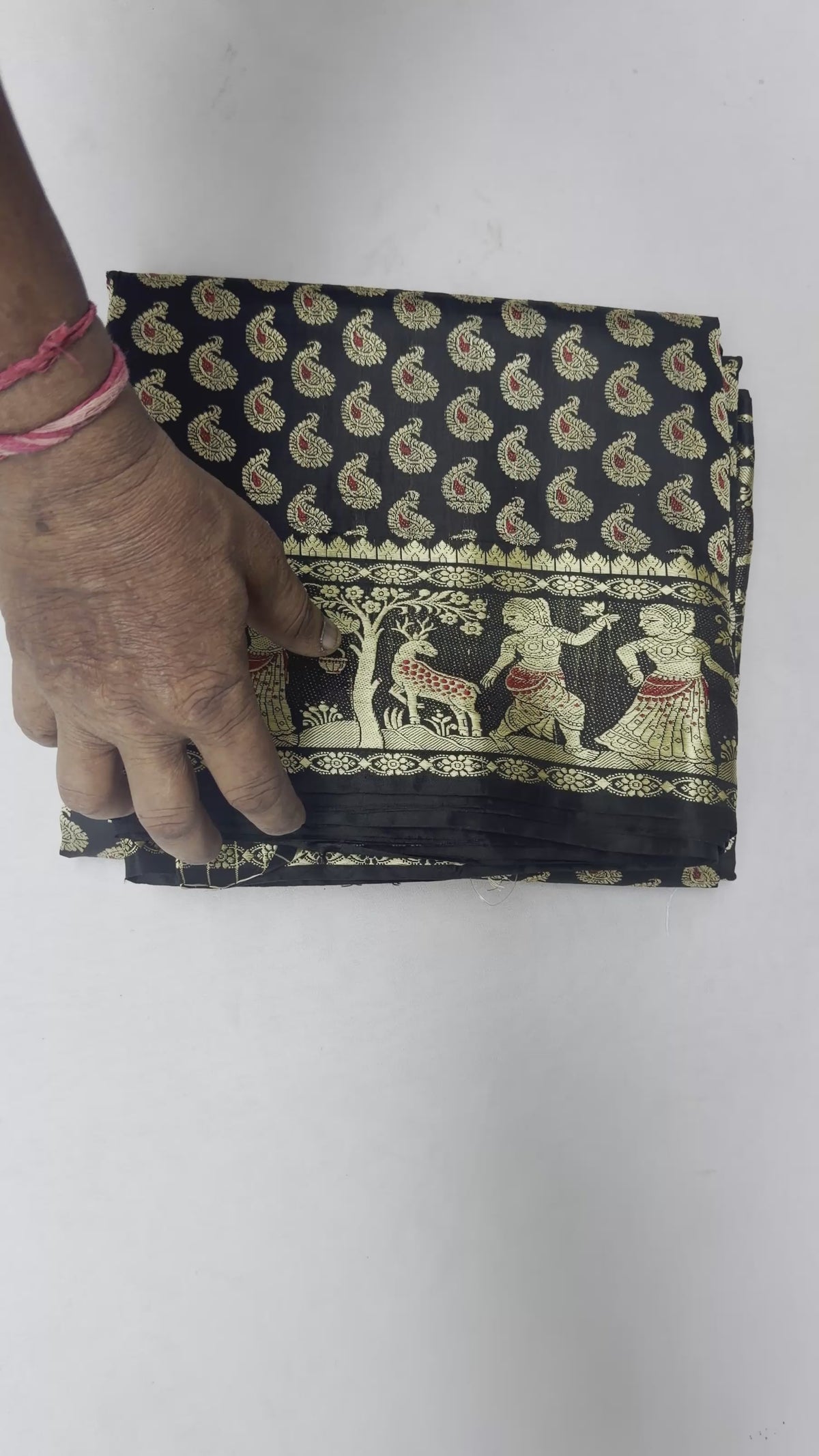 Full saree view highlighting black pleats and warm gold-toned storytelling panels on the pallu