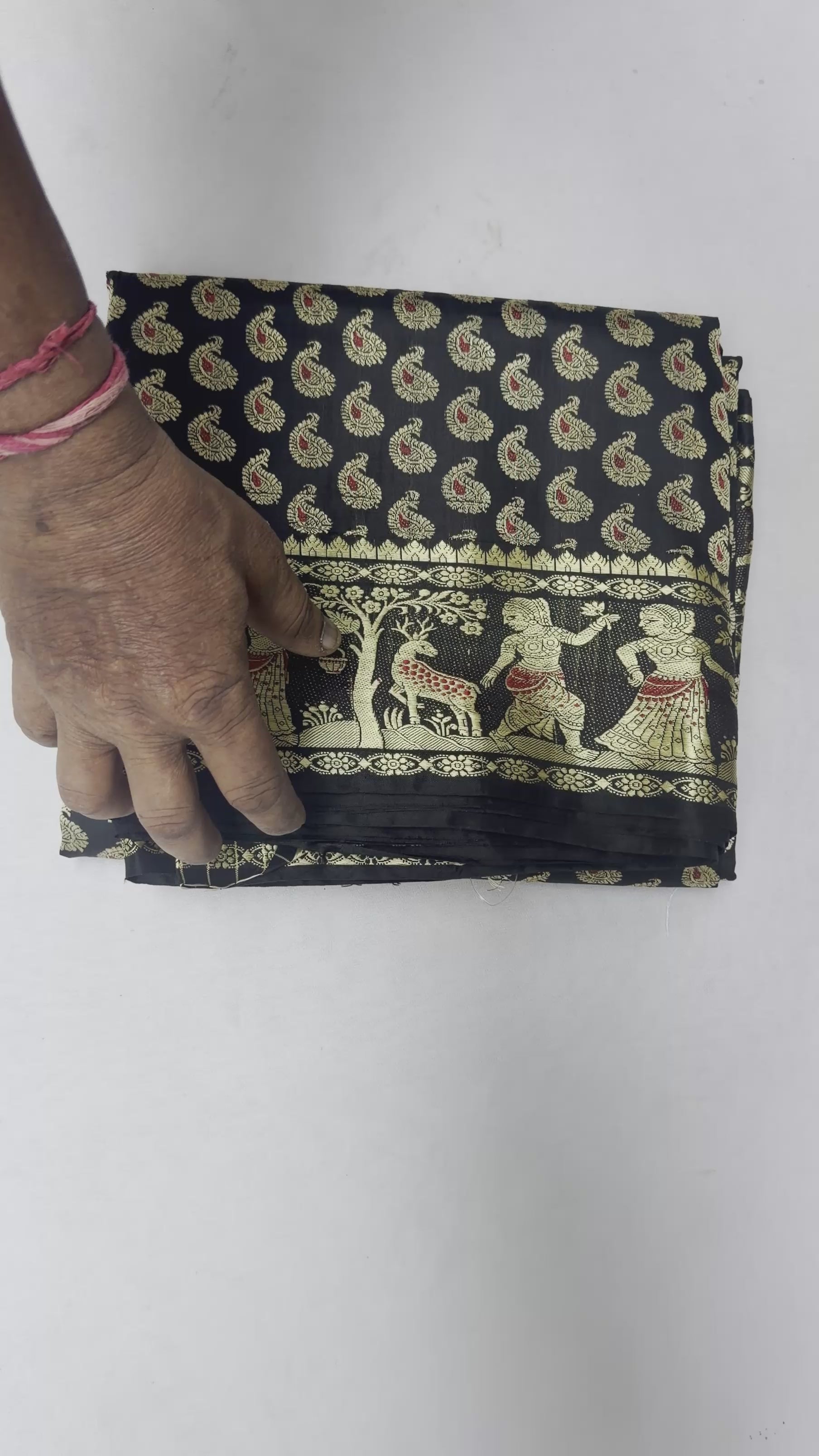 Full saree view highlighting black pleats and warm gold-toned storytelling panels on the pallu