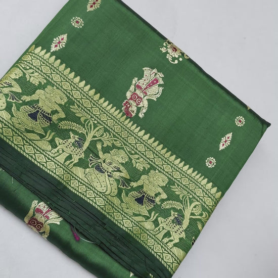 Full saree view highlighting emerald green pleats, gold-toned borders and the figurative paisley pallu