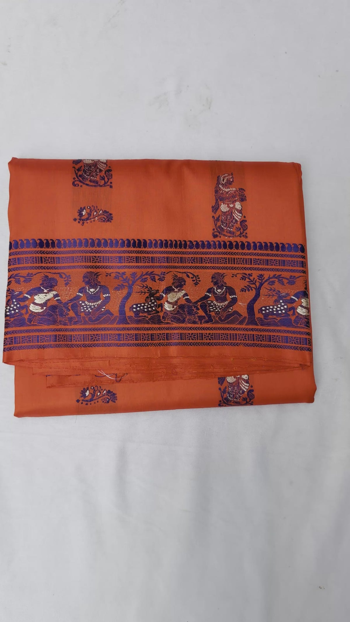 Full saree view highlighting orange pleats and the elaborate figurative pallu⠋